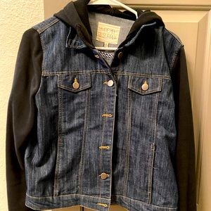 Jean jacket with black sleeves.
